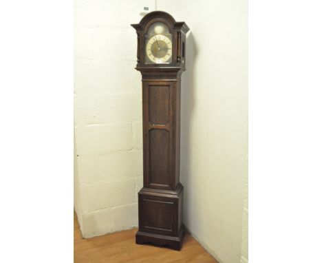 A 1920's Grandmother longcase clock, stained oak case, the silvered ring dial with Roman numerals denoting hours, chiming eve