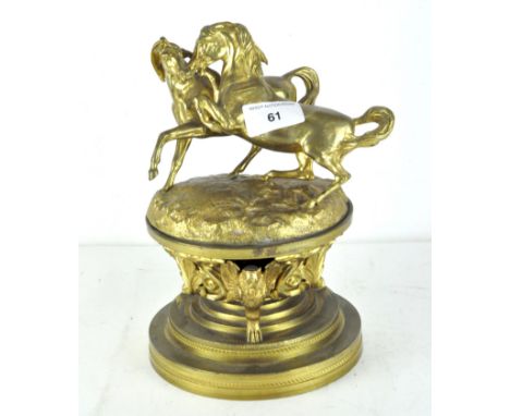 A late 19th/early 20th century gilt brass inkwell, the top adorned with two stylised horses, 23cm high