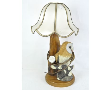 A turned and carved oak lamp base set with a resin figure of a barn owl on a branch, with shade, the base 33cm high (max)