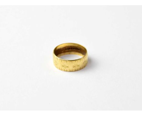An 18ct gold band ring with repeating pattern, size M, approx 4.6g.