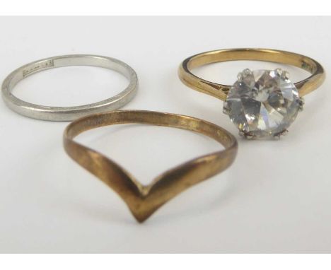 Three dress rings comprising a thin platinum band, size K, approx. 1.7g, a 9ct gold wishbone ring, size J, approx. 0.6g and a