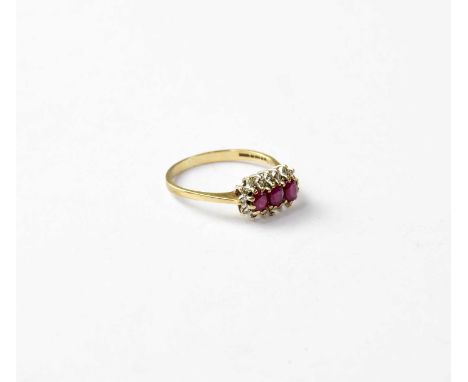 A vintage 9ct gold ruby and diamond cluster ring, the three claw set oval rubies within a border of tiny claw set diamonds, o