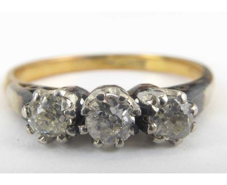 An 18ct gold three-stone diamond ring, the three tiny claw set diamonds on a white metal mount, size M, approx. 2.5g.