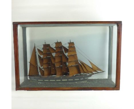 A late 19th/early 20th century wooden model of a four-masted sailboat titled 'Mary', on modelled choppy waters, in a glazed c