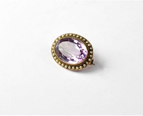 A Victorian oval brooch set with large faceted amethyst with seed pearl surround.
