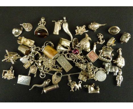A vintage silver charm bracelet with approximately thirty-four silver charms, to include helicopter, Tibetan monument, bucket