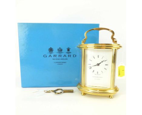 GARRARD, LONDON; a modern brass oval carriage clock with bevel edge glazed panels, the white dial set with Roman numeral incr