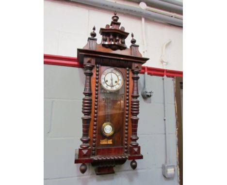 An early 20th Century walnut cased Vienna wall clock with turned finial detail