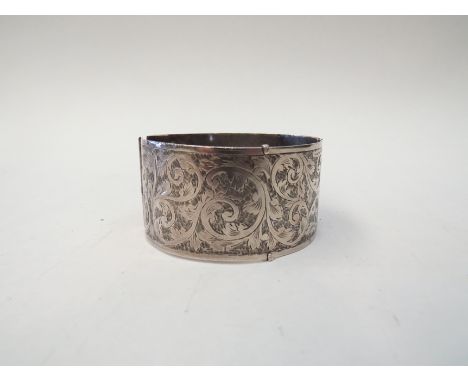 A silver bangle engraved with scrolling foliage, hallmarked Birmingham