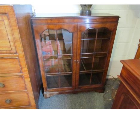 A pair of burr walnut panel glazed two door bookcases with working locks and keys, the height adjustable shelves over bracket