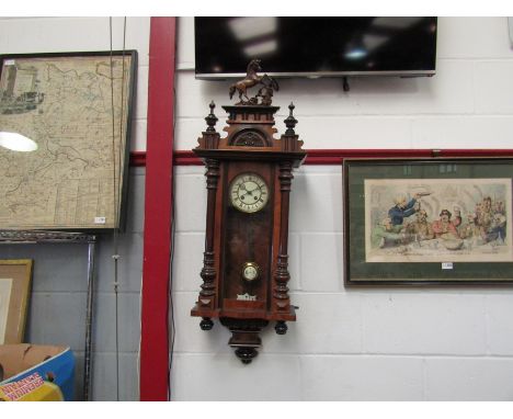 An early 20th Century walnut Vienna wall clock with Roman dial, turned finials and horse crest