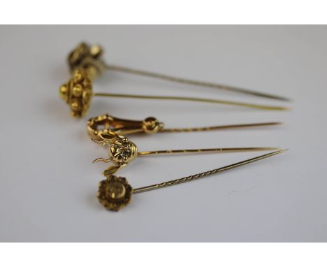 Five yellow metal stick pins to include a 15ct yellow gold Edwardian stick pin with horseshoe design; a yellow metal cannetil