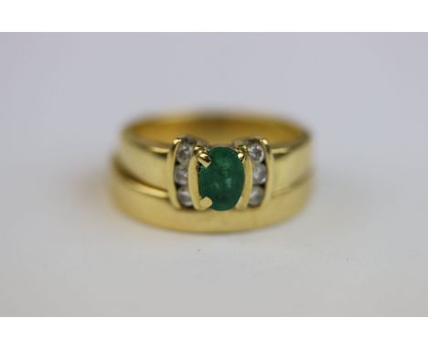 Emerald and diamond 18ct yellow gold ring, the central oval mixed cut emerald measuring approximately 6mm x 4mm, claw setting