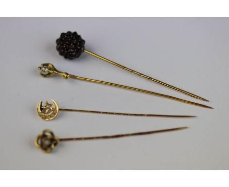 Four Victorian and later yellow metal stick pins, to include a garnet cluster stick pin, a pearl set knot design stick pin; a