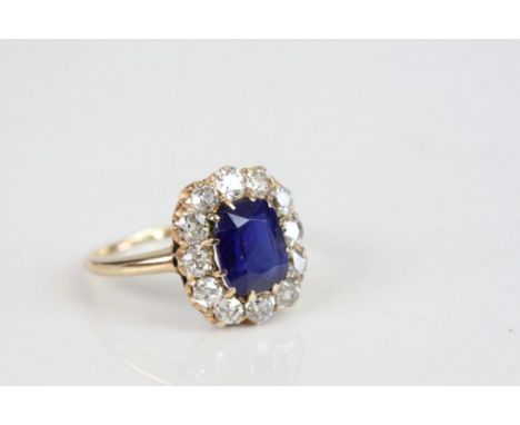 Sapphire and diamond oval cluster yellow gold ring, the central cushion cut blue sapphire possibly a soude sapphire, claw set