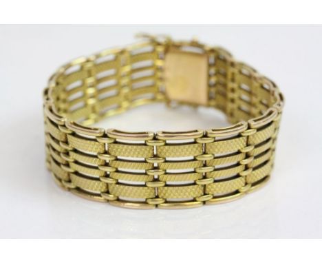 Yellow metal gate link style bracelet, textured panels, tongue and box snap clasp, width approximately 2cm, length approximat