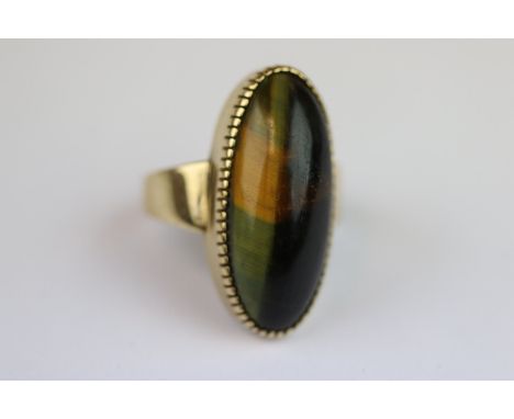 Tigers Eye unmarked gold ring, the elongated oval cabochon cut tigers eye displaying partial cat's-eye, the stone measuring a