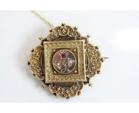 Victorian seed pearl and red spinel yellow metal brooch of quatrefoil form, the central raised circular panel with engraved s