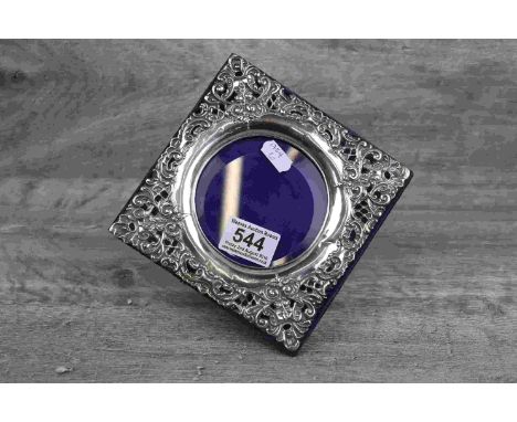 Edwardian silver easel back square photograph frame with circular glazed panel to centre and pierced foliate scroll decoratio