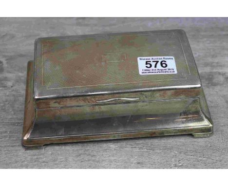 Silver cigarette box raised on four feet, flared moulded form, engine turned decoration to lid, chevron design to corners and