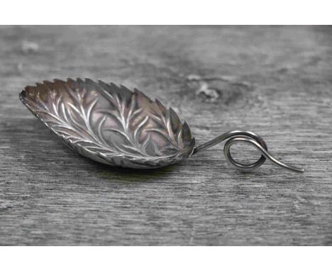 White metal novelty caddy spoon modelled as a vine leaf, repousse vein decoration to leaf shaped bowl, scrolled stem, length 