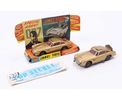 2 Corgi Toys No. 261 James Bond's Aston Martin DB5, both with a gold body, red interior, and wire wheels, one model has the b