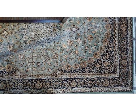 A Kashan style carpet with central floral medallion on a green ground contained by many floral borders. 230x160cm 