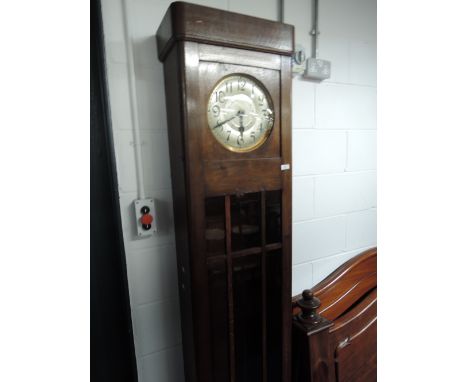 An early 20th century oak cased grandmother clock of rectangular design with circular silvered dial and glass trunk