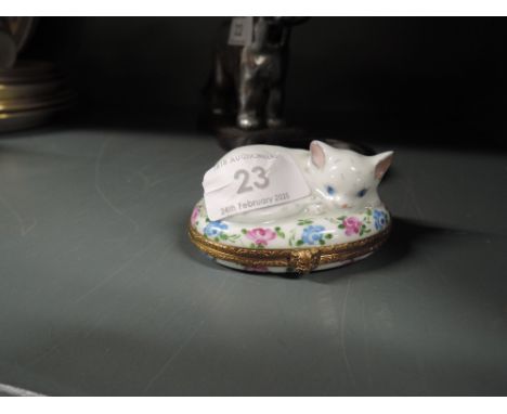 A ceramic trinket case by Limoges hand decorated and designed as a cat in a basket