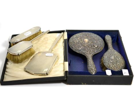 A large silver backed mirror and brush, Birmingham 1919, cased; together with an Art Deco silver mirror and two brushes, Shef