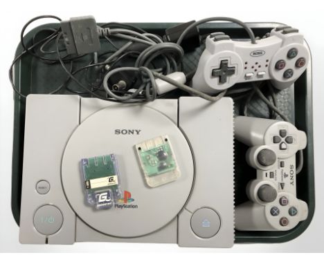 A Sony Playstation 1 console, model SCPH-9002, with two controllers and leads.
