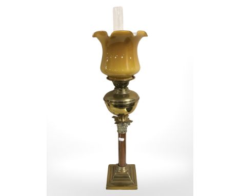 A brass Corinthian column oil lamp, with butterscotch glass shade and clear chimney, height 74 cm.
