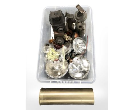 A large brass ammunition shell casing, vintage car headlamps and bulbs, cast iron hydraulic jacks. (1 box)