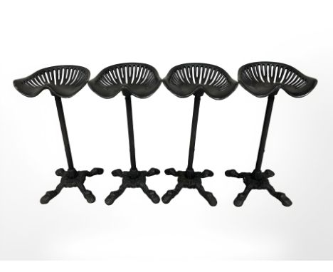 A set of four painted cast iron tractor seat bar stools.