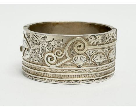 A late 19th century ornate silver bangle. By Sydenham Brothers. Birmingham. 38.39 grams. 6x5.5cm closed. 
