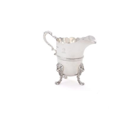 
	
		A SILVER CREAM JUG
		WAKELY &amp; WHEELER, LONDON 1918
		With a shaped border, a leaf capped double scroll handle, engra
