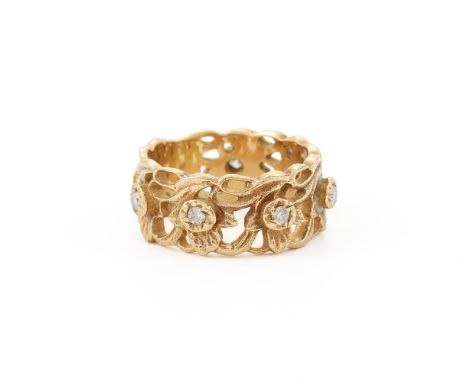 
	
		STUART DEVLIN, AN 18 CARAT GOLD DAFFODIL RING 
		LONDON 1988 IMPORT MARK
		The band pierced with daffodils, diamond acce