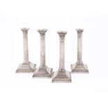 A SET OF FOUR ELECTRO-PLATED CORINTHIAN CANDLESTICKS