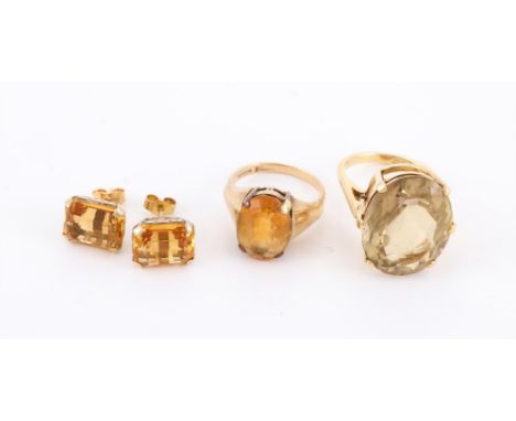 
	
		TWO CITRINE DRESS RINGS AND A PAIR OF CITRINE EAR STUDS 
		The first with an oval cut citrine within an 18 carat gold si