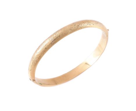 
	
		A SWEDISH GOLD COLOURED HINGED BANGLE 
		The polished bangle with floral engraved decoration, stamped 18k with Swedish c