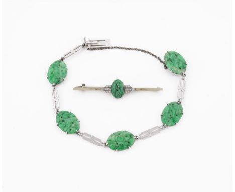 
	
		A 1930S JADEITE JADE AND WHITE GOLD BRACELET AND A SIMILAR BAR BROOCH
		The oval pierced panels carved with fruit and le