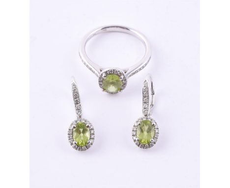 
	
		A PERIDOT AND DIAMOND CLUSTER RING AND A MATCHING PAIR OF EAR PENDANTS 
		LONDON 2007
		The 18 carat white gold ring wit