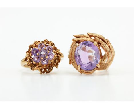 
	
		TWO 9 CARAT GOLD AMETHYST DRESS RINGS 
		The first with a single oval cut amethyst within a textured leaf like surround,