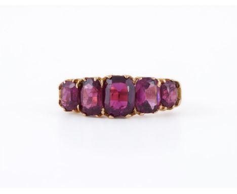 
	
		A FIVE STONE GARNET RING 
		The graduated cushion cut garnets in stepped polished gold coloured settings, the shank stam