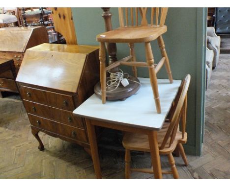 A Walnut three door bureau on claw and ball feet, a standard lamp, two Beech wheel back chairs and a formica top table