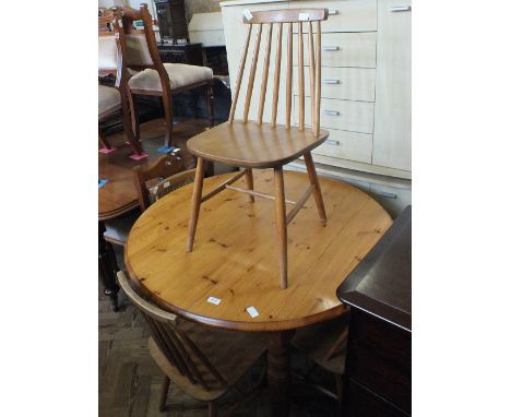 A modern circular Pine breakfast table and a set of four stick back chairs