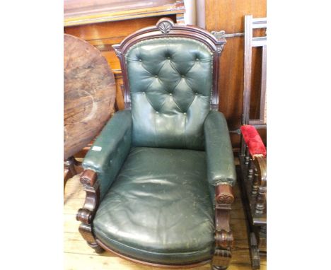 A Victorian carved Mahogany armchair with green leather button back upholstery