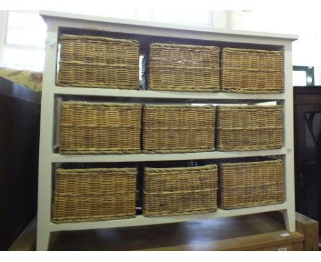 A modern kitchen shelf unit with nine removable white wicker baskets