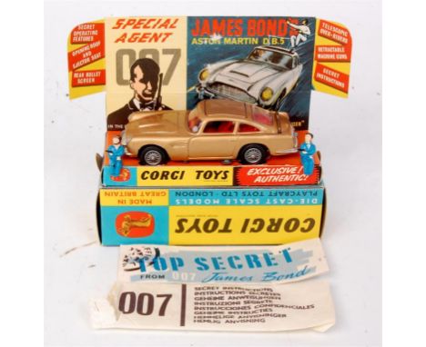 Corgi Toys, 261 James Bond's Aston martin DB5, gold body with red interior and wire hubs, with 2 bandit figures, secret instr