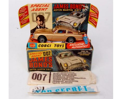 Corgi Toys, 261 James Bond Aston Martin DB5, gold body with red interior and wire hubs, 2 bandit figures, with secret instruc